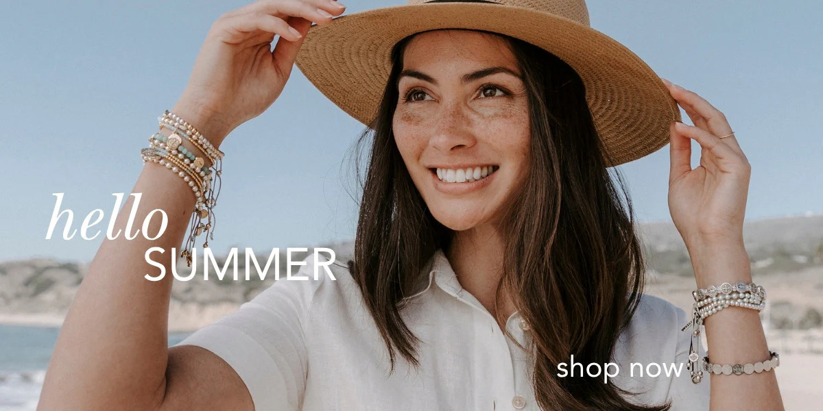 Hand holding pastel blessing bracelets with gold accents – faith jewelry collection