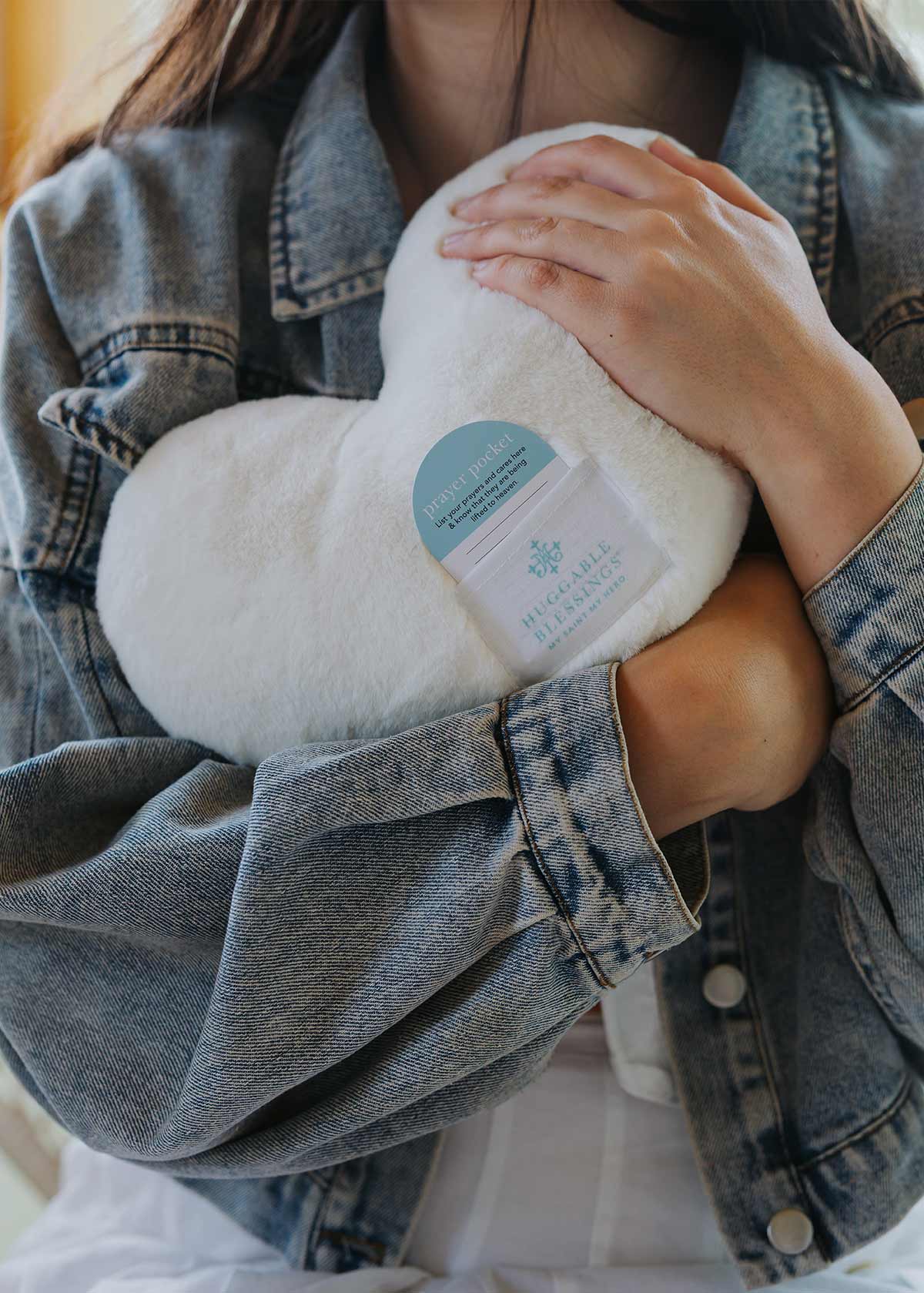 Hands hugging heart-shaped pillow – Christian home blessing gift